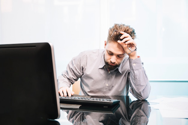 a tired man sitting at a computer