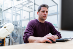  a person staring at a computer screen in concentration