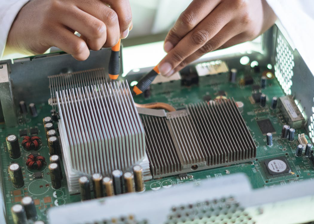 PC repair technician working on a motherboard, checking connections carefully