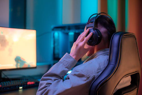 a person wearing headphones while playing game on a computer