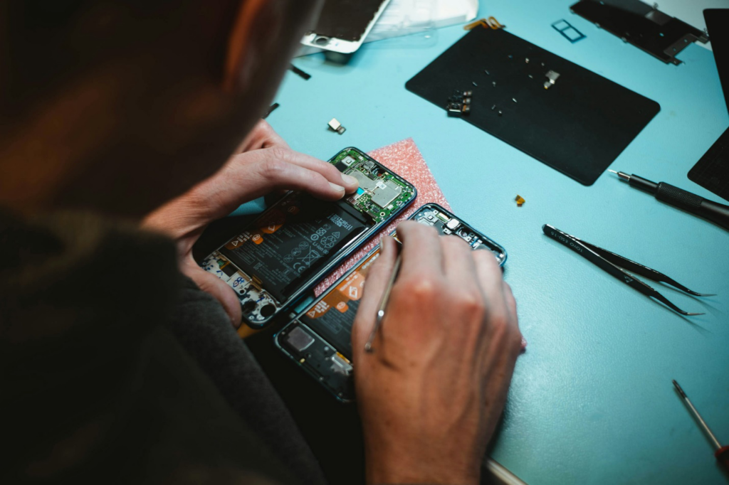 A person fixing a phone or computer hardware.