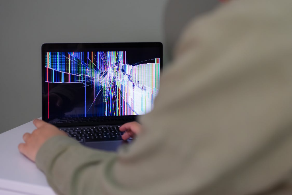 A person working on their broken laptop.