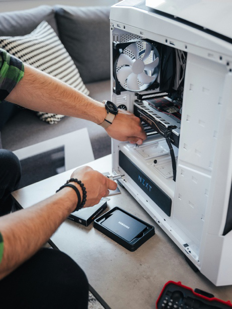 A professional computer technician installs new internal components to improve system speed and overall performance during a desktop computer upgrade.