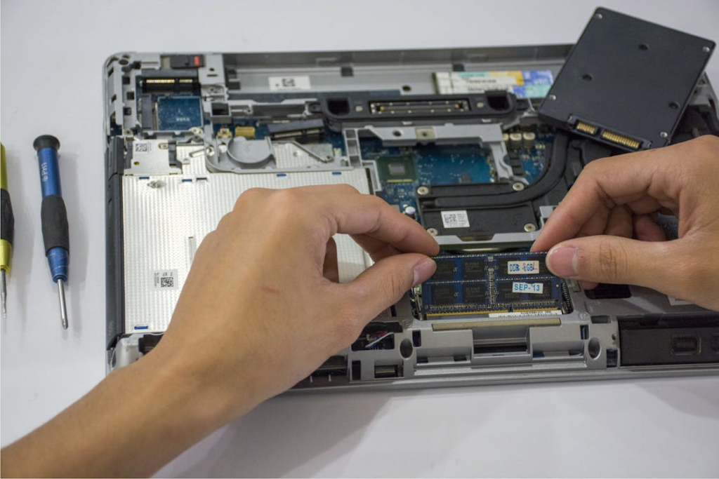 A technician working on the internal parts of a laptop