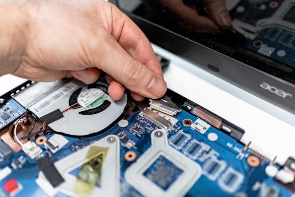 A technician working on the internal parts of a laptop