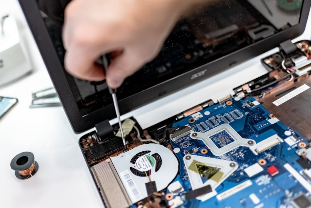 A technician working on the internal parts of a laptop
