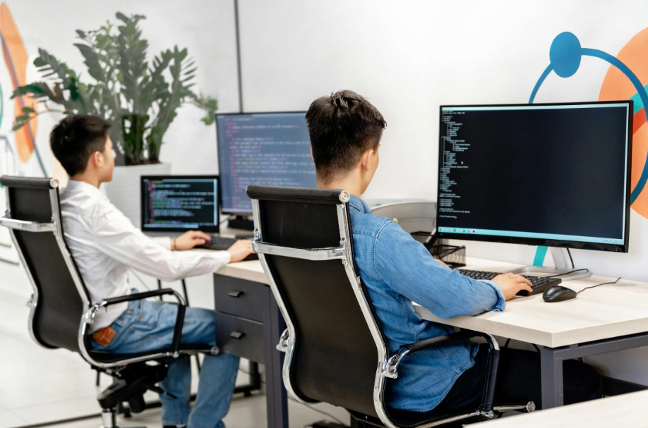 Two people coding on computers.