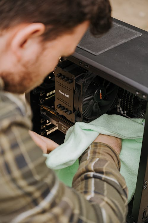 A man cleaning the inside of a CPU